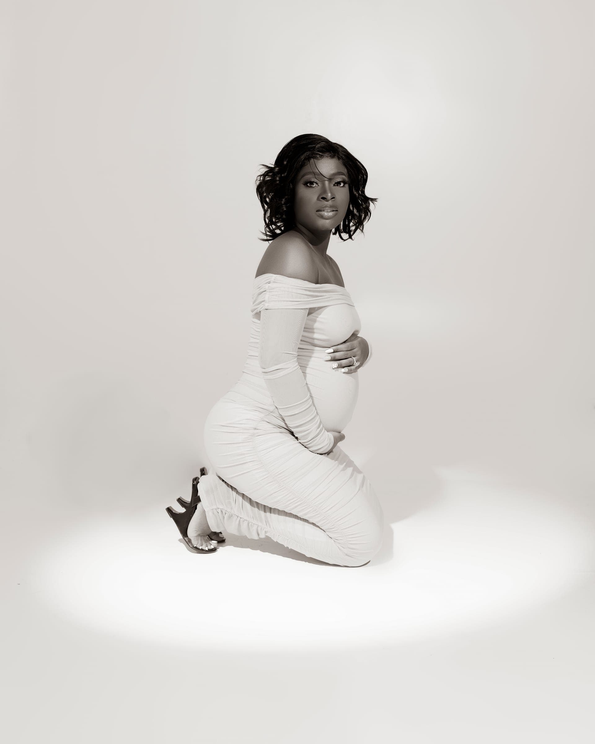 Maternity portrait photographed against a minimal studio backdrop.