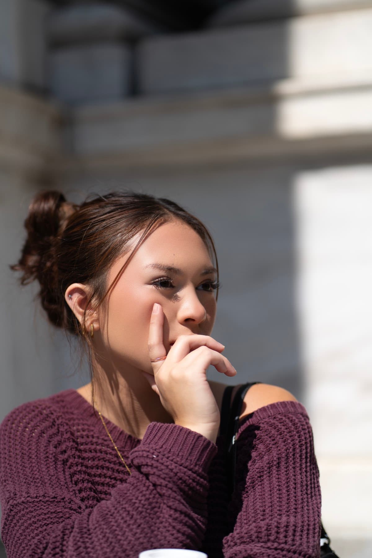 Lifestyle portrait with a candid posture in crisp daylight.